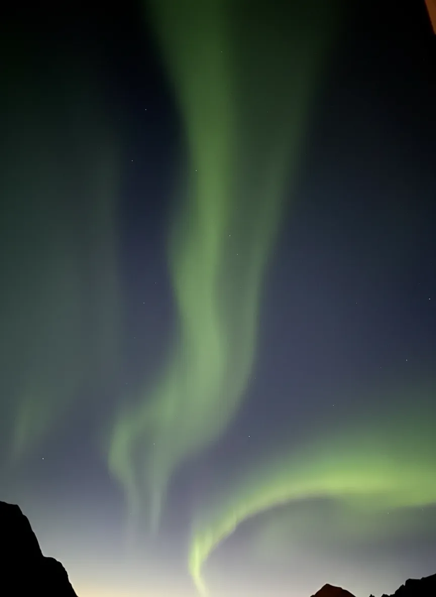 Nordlys som flammer over fjorden i Ersfjordbotn